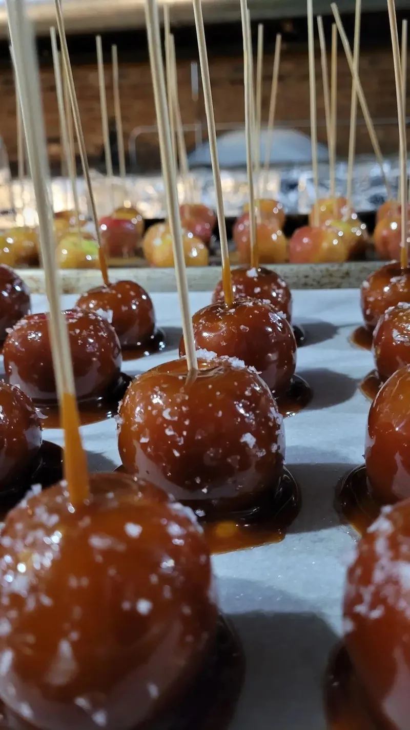 Caramel-dipped treats on sticks, lined up for service