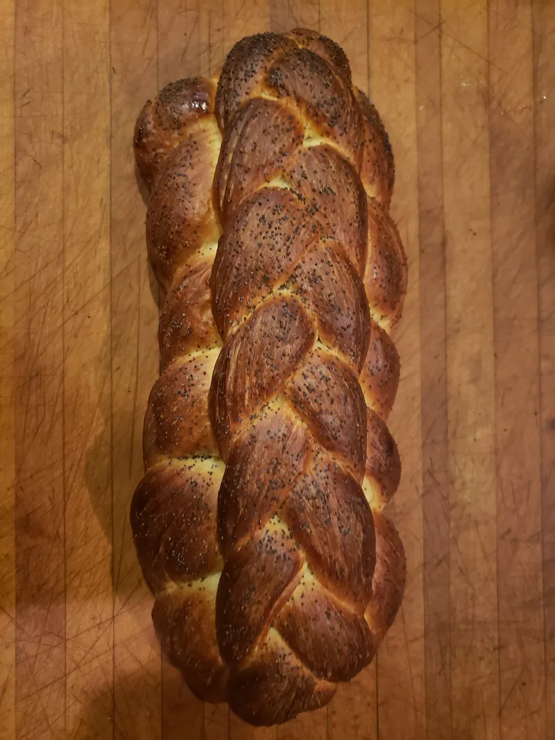 Braided seeded loaf on a wooden cutting board